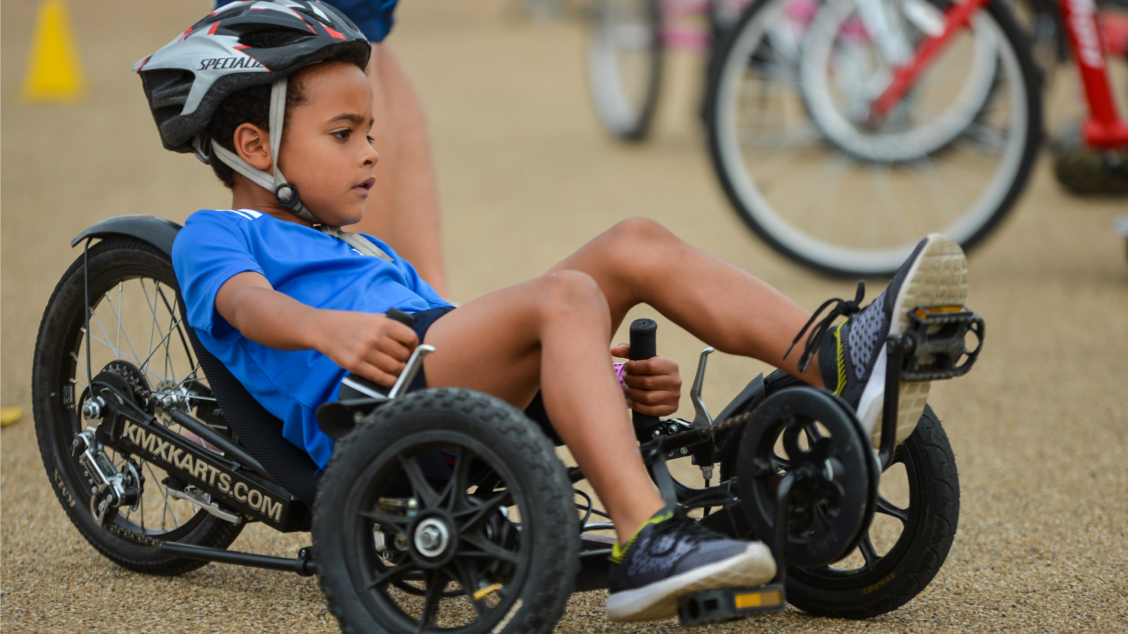 Boy pedalling a recumbent bike